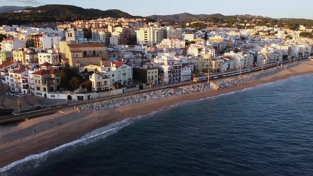 Aerial view of train passing throug Sant Pol de Mar in el Maresme coast, Catalonia, Spain.