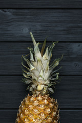 Ripe pineapple with leaves on wooden background. 