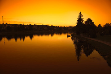 Obraz premium Landscape with river in front flowing at sunset sky