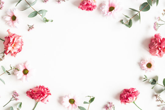 Flowers composition. Frame made of pink flowers and eucalyptus branches on white background. Valentines day, mothers day, womens day concept. Flat lay, top view
