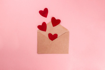 Red hearts flying out from craft paper envelope flat lay on colorful pink background. 8 march, Mother's day, Valentine's Day celebrating. Top view with copy space. Template for web, media. Stock photo