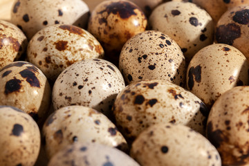 Obraz premium Quail eggs stacked on a yellow bamboo plate.