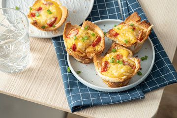 Baked egg, ham, tomato and toast cup for breakfast brunch.