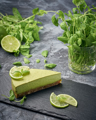 Slice of raw green cheesecake with lime and mint, decorated slice of lime. Healthy organic summer...