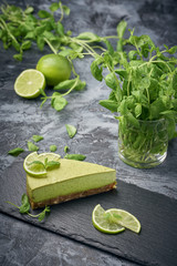 Slice of raw green cheesecake with lime and mint, decorated slice of lime. Healthy organic summer dessert pie.