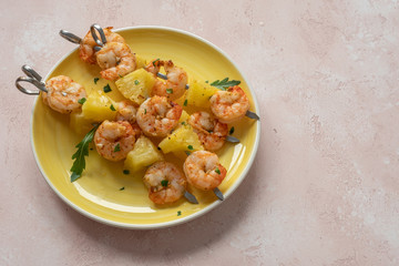 skewers of barbecued shrimp with a pineapple