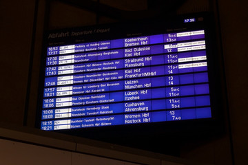 Fototapeta premium Digital display board for the departure of trains to various German cities at Hamburg main station, dark background