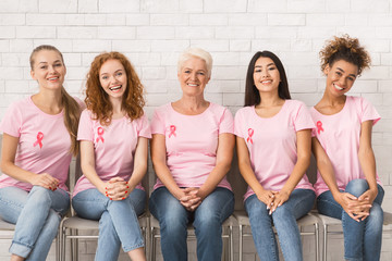 Multiracial Women In Pink Awareness T-Shirts Sitting On Chairs Indoor