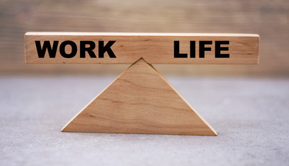 concept of work-life balance on wooden scales