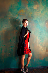 young pretty brunette woman in fashion dress posing elegant on green background interior, lifestyle luxury people concept