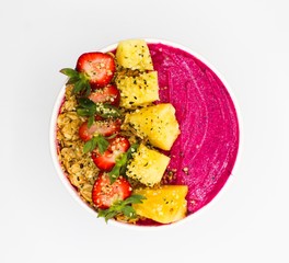 Aerial Shot of a Red Smoothie Bowl with Strawberries, Pineapple, and Nuts With A White Background