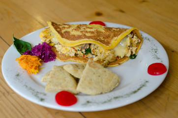 Omelette with a lot of cheese, accompanied by arepa