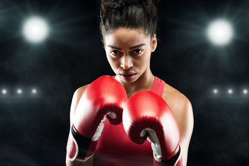 Confident black woman boxer standing in pose, ready to fight