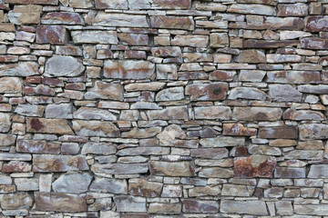 Background, texture. The wall is made of wild natural stone, gray.