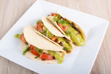 Mexican tacos with chicken, vegetables and guacamole