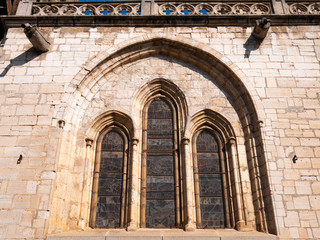 Stained glass windows of a cathedral seen from the outside in an ogival arch on a stone facade