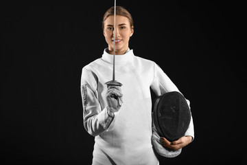 Young female fencer on dark background - obrazy, fototapety, plakaty