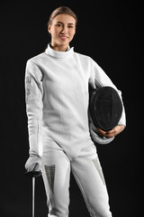 Young female fencer on dark background