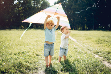 Little child in a summer field. Kids playing with a Kite