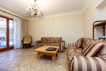 Luxury room in beige tones in a classic style with two brown-striped sofas and a coffee table
