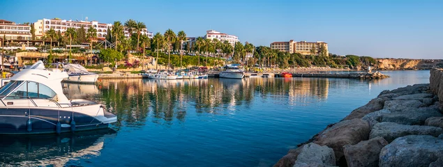Gordijnen Kustpanorama van Cyprus met jachten, boten, palmen aan de waterkant en hotelgebouwen. Mediterraan resort voor reizen en vakantie. © DedMityay