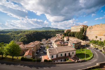 Fototapeta na wymiar Panoramic view of small vilage in Italy with red brick houses and towers and nature in Sovana Sorano with beautiful sky with clouds in Lazio region Viterbo province in Italy