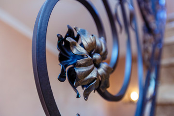 Black openwork staircase with wrought iron railings in the form of floral ornaments