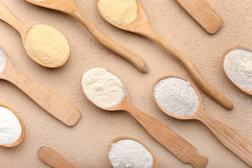 Fototapeta na wymiar Spoons with different flour on color background