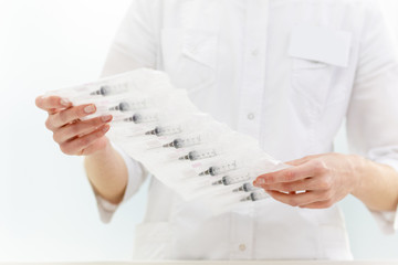 pharmacist holds a pack of injections