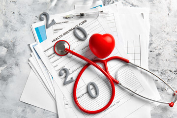 Stethoscope, figure 2020 and documents on white background
