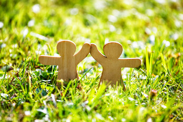 Wooden little men holding hands. Teamwork, friendship and love concept