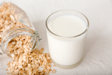 Glass of tasty oat milk on white background