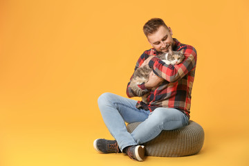 Fototapeta na wymiar Man with cute cat on color background