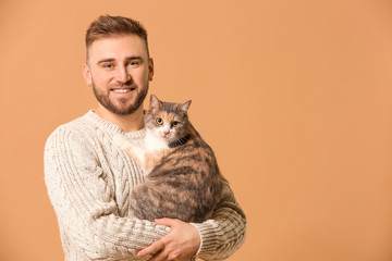 Man with cute cat on color background