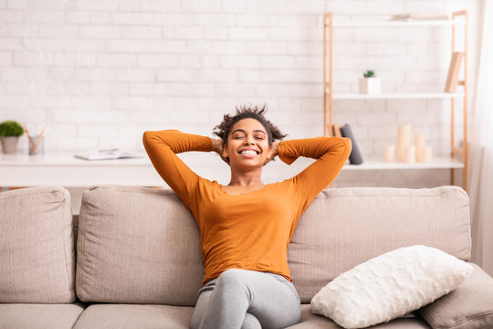 Happy Black Woman Relaxing Sitting On Sofa At Home