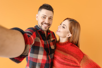 Couple taking selfie on color background