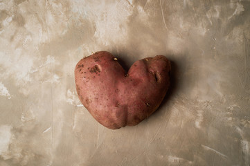 Fototapeta premium Ugly food, potatoes in the shape of a heart. Natural and simple farm products.