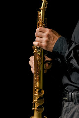Fototapeta premium soprano saxophone in hands on a black background