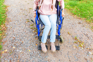 Legs feet handicap woman in wheelchair wheel on road in hospital park waiting for patient services....