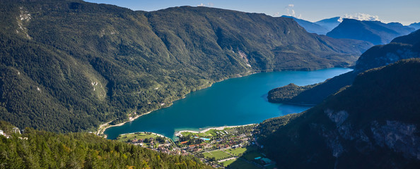 Fototapeta na wymiar Aerial view over the beautiful Molveno town and Molveno lake, an alpine lake in Trentino, Italy