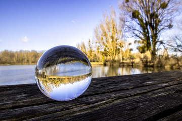 Boule de cristal en gros plan sur une table en bois au bord d'un lac - Voyance - Ésotérisme