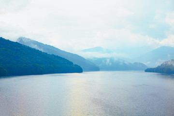 Obraz premium river and mountains range in the foggy day