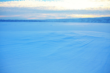 winter scenery with low clouds over the frozen lake 