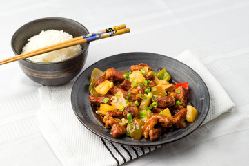 Sweet and sour pork chinese food. Deep fried meat is added to stir fried pineapple, onions, peppers and sauce. Sweet and sour dishes are common in asian cuisine, especially American Chinese food.
