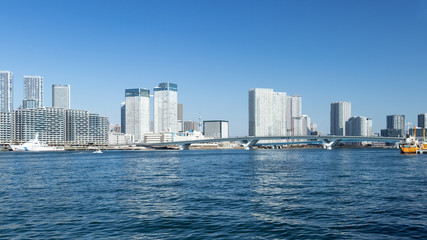 青空を背景に豊洲ふ頭から見た東京湾岸のビル群
