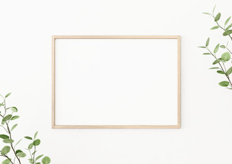 Interior poster mockup with horizontal wooden frame on empty white wall, decorated with plant branches with green leaves. A4, A3 size format. 3D rendering, illustration. - obrazy, fototapety, plakaty
