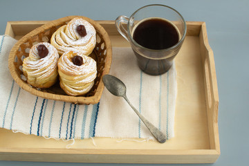 Cruffins without filling with a cup of espresso on a wooden tray.