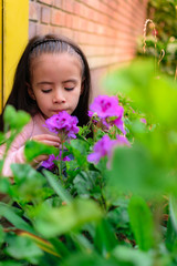Colombian Latin American girl smells the flowers in the garden of her house