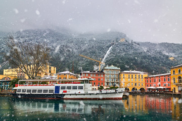 View of the beautiful Lake Garda surrounded by mountains,Riva del Garda town and Garda lake in the winter time on a snowy day,Trentino Alto Adige region