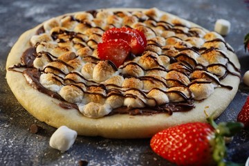 Homemade s'mores desser tpizzatopped with toasted marshmallows and chocolate drizzle